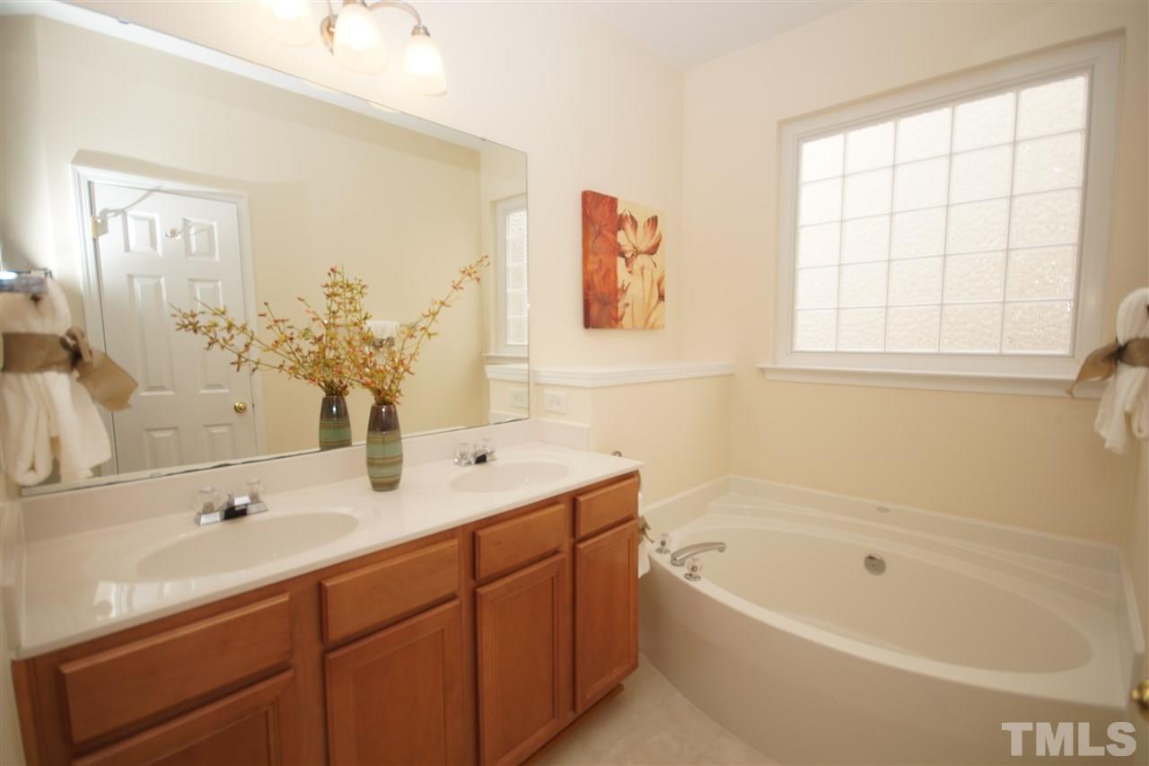 8429 Header Stone Drive Raleigh, NC 27613 - Photo 14 of 19 a bathroom with a tub a sink and mirror