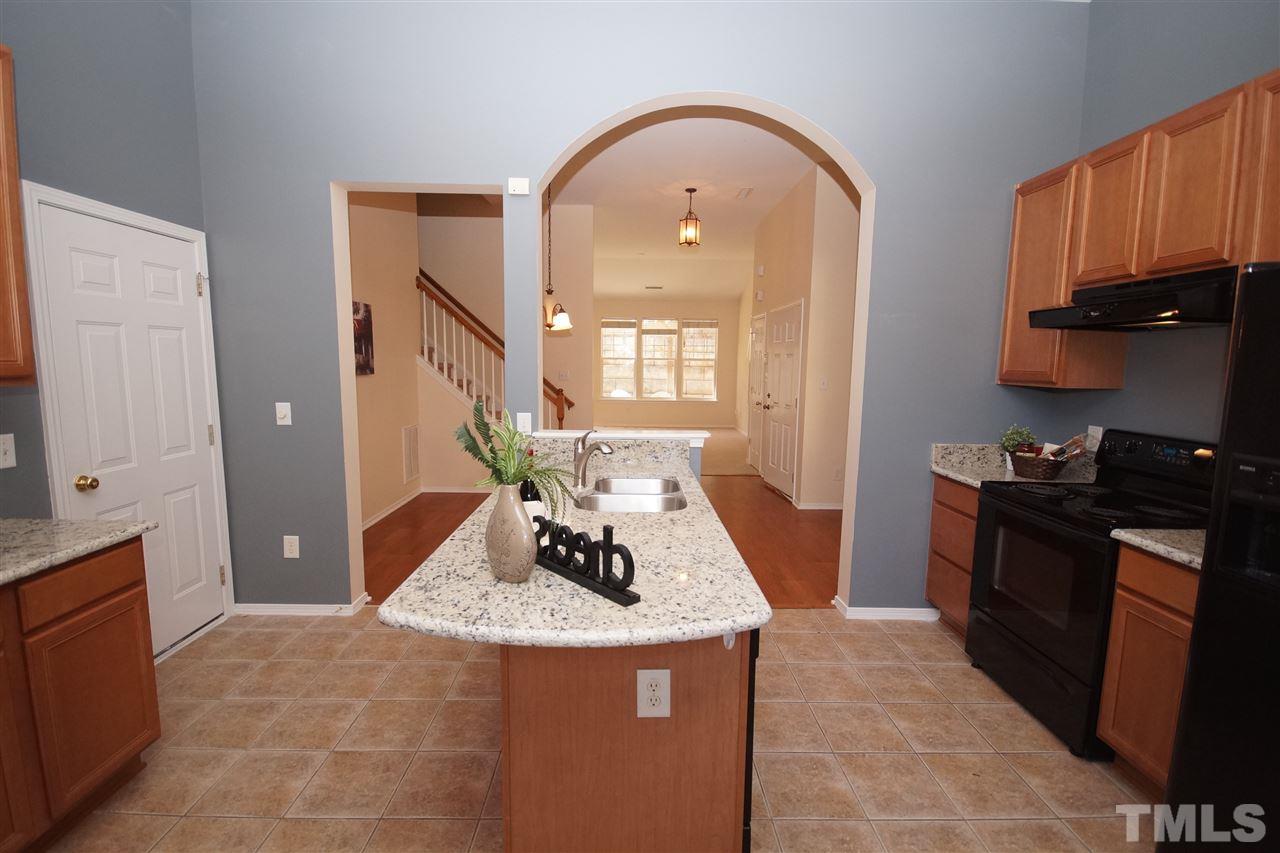 8429 Header Stone Drive Raleigh, NC 27613 - Photo 8 of 19 a kitchen with granite countertop a stove refrigerator and cabinets