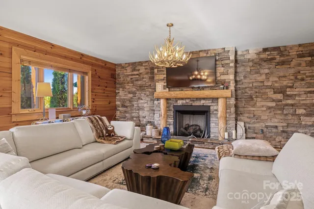 a living room with furniture a fireplace and a chandelier
