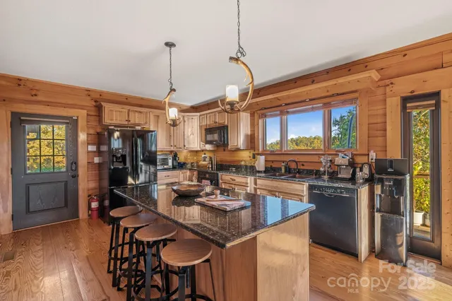 a kitchen with granite countertop kitchen island stainless steel appliances a table and chairs