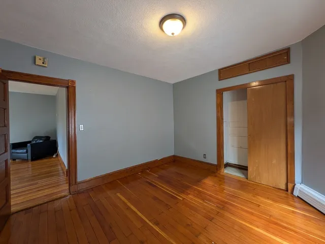 a view of a room with wooden floor and a bathroom