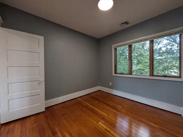 a view of a room with wooden floor and a bathroom