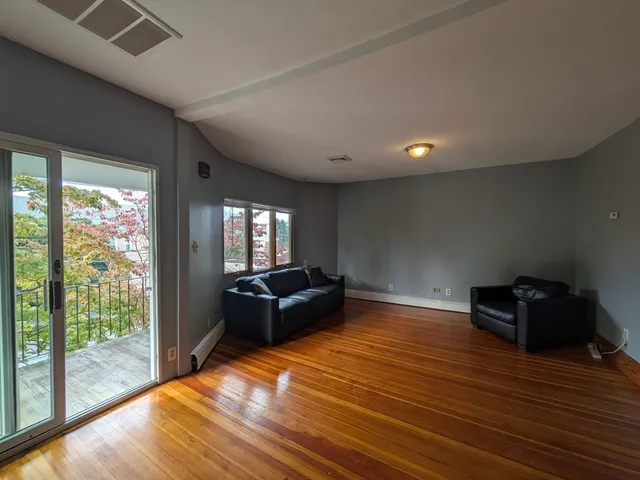 a living room with furniture window and wooden floor