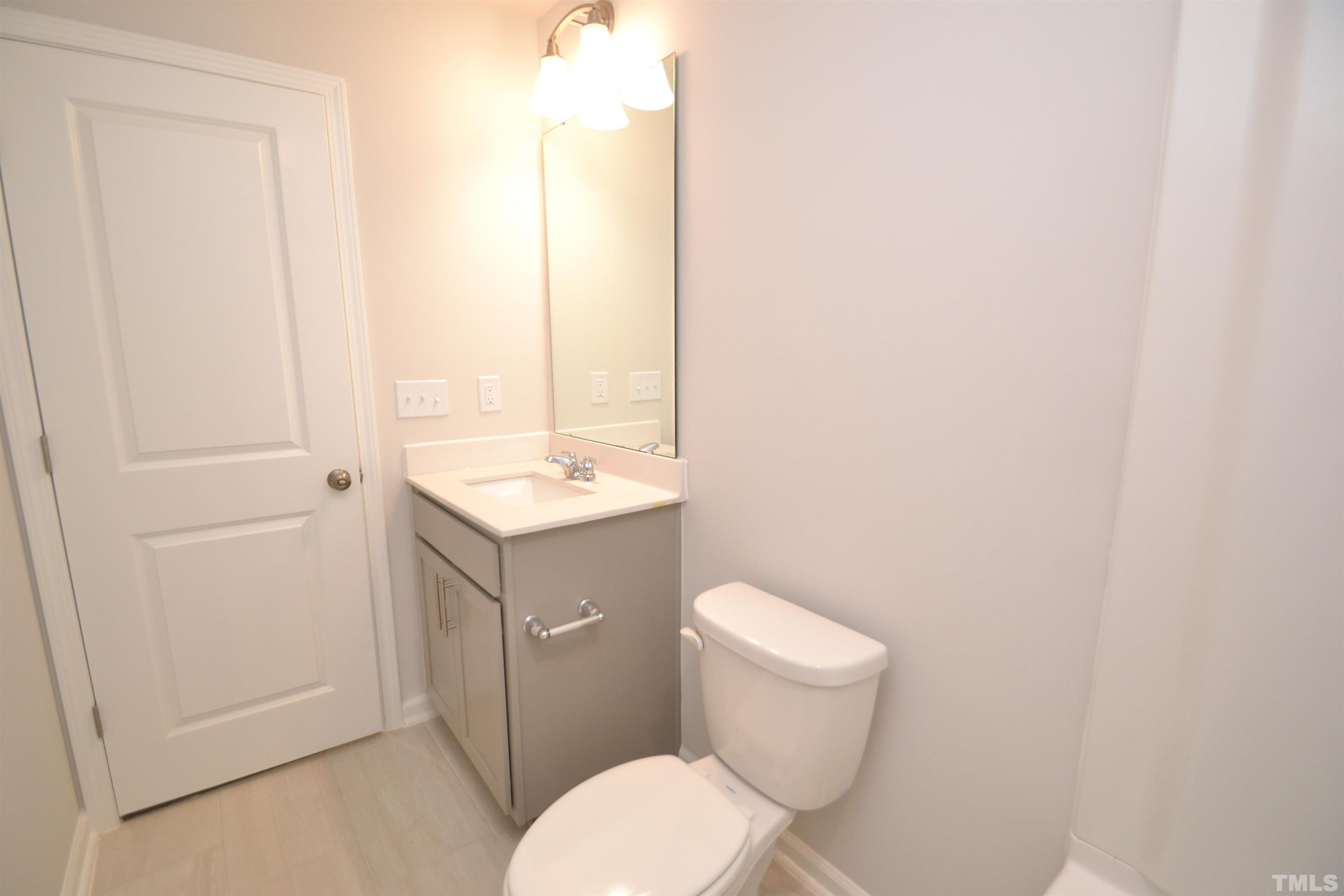 1837 Joscara Lane Apex, NC 27502 - Photo 11 of 45 a bathroom with a toilet a sink and a mirror