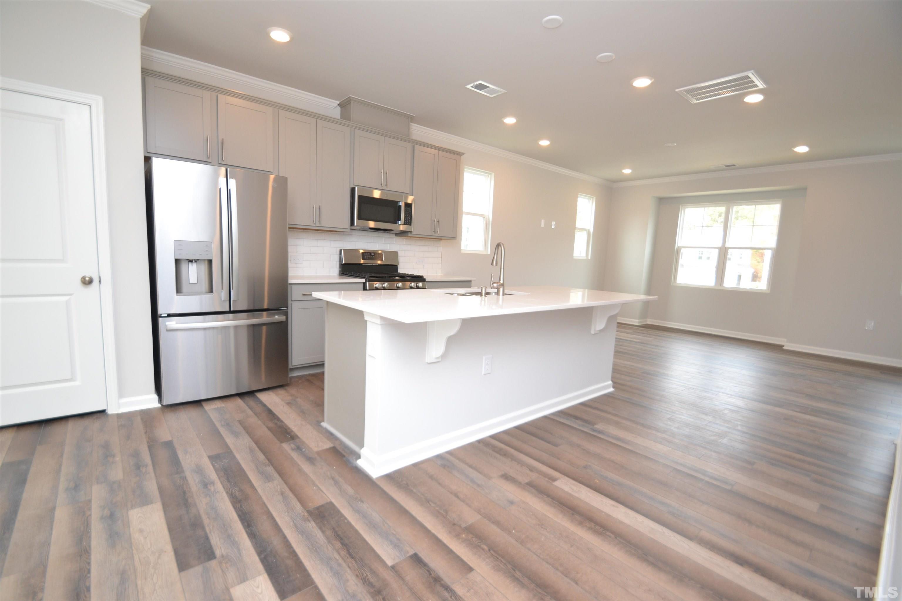 1837 Joscara Lane Apex, NC 27502 - Photo 12 of 45 a kitchen with stainless steel appliances a refrigerator sink and microwave