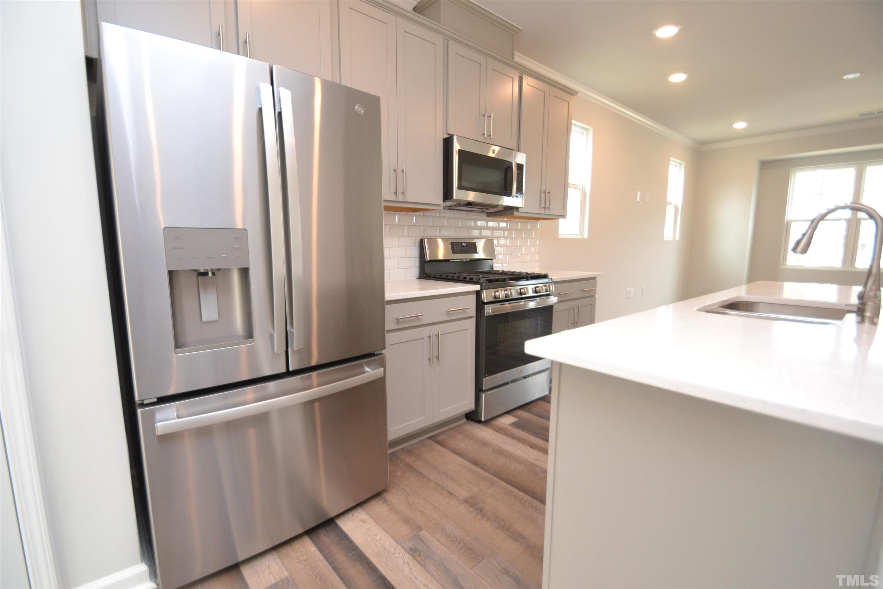 1837 Joscara Lane Apex, NC 27502 - Photo 16 of 45 a kitchen with stainless steel appliances a refrigerator stove microwave and sink