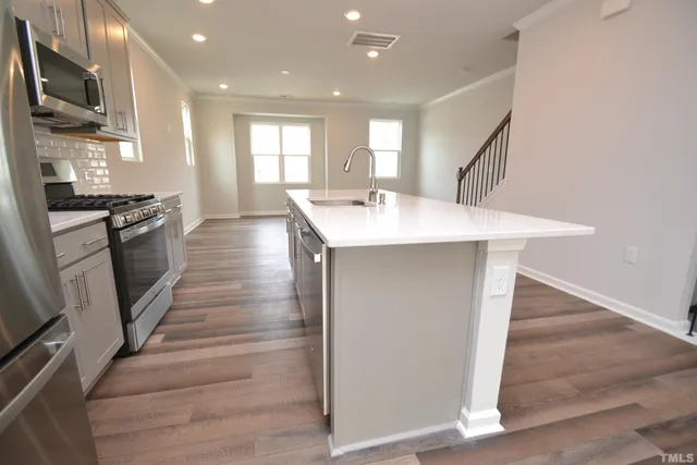 a kitchen with stainless steel appliances granite countertop a sink a stove and a refrigerator