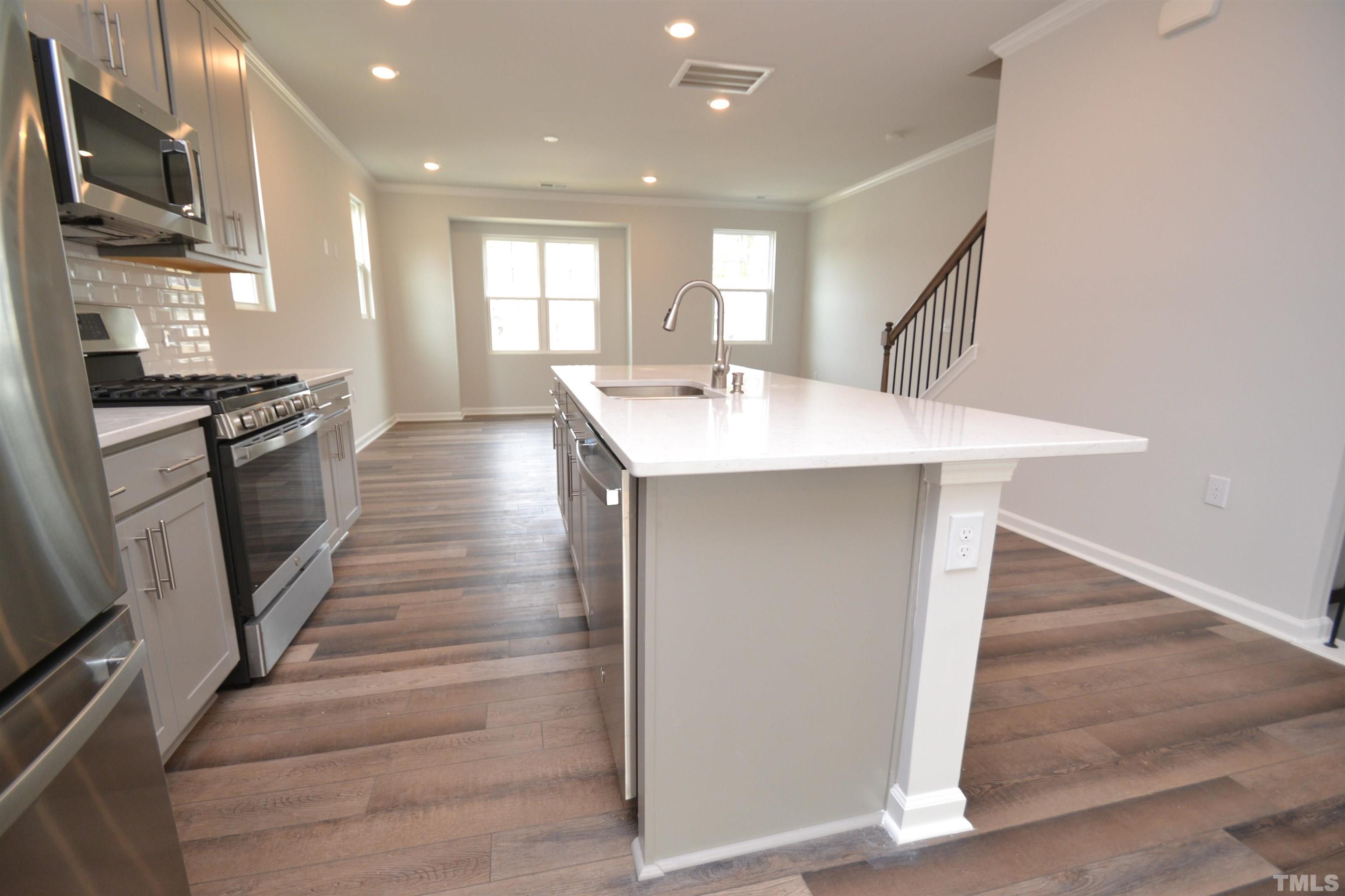 1837 Joscara Lane Apex, NC 27502 - Photo 17 of 45 a kitchen with stainless steel appliances granite countertop a sink a stove and a refrigerator