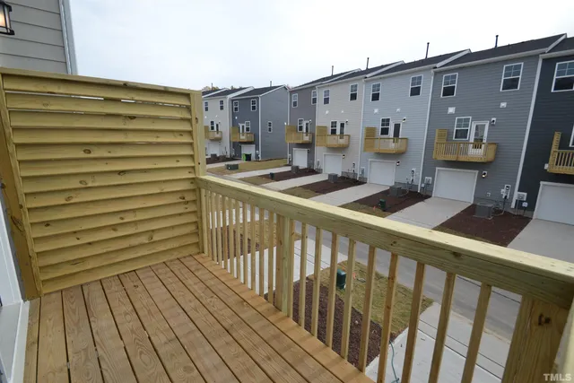 a view of a balcony with wooden floor and furniture