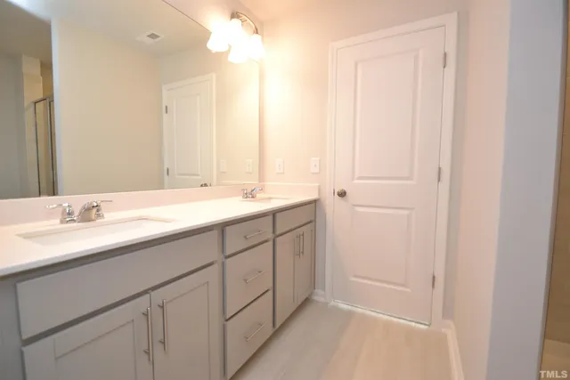 a bathroom with a double vanity sink and a mirror