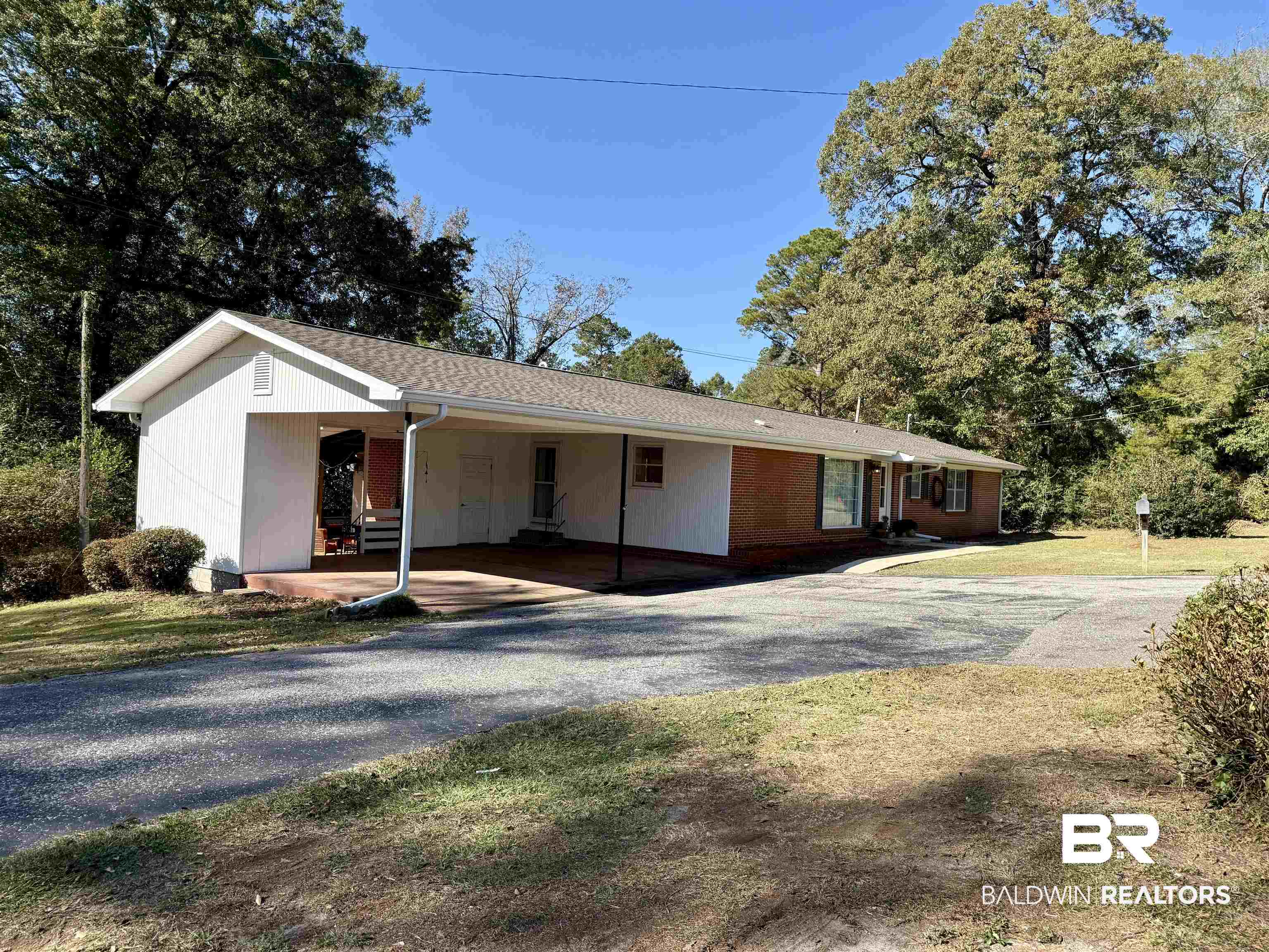 2785 Appleton Road Brewton, AL 36426 - Photo 2 of 28 Ranch-style house featuring driveway, an attached carport, a front lawn, a shingled roof, and covered porch