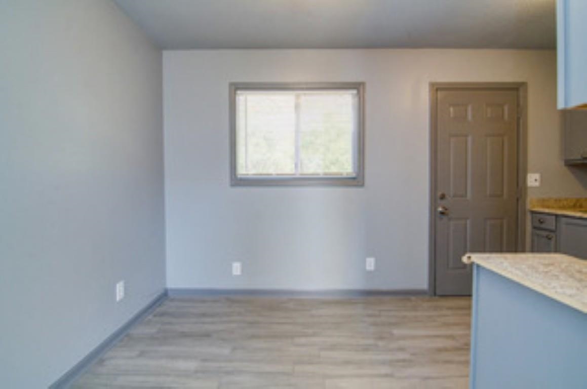396 West Holmes Road Memphis, TN 38109 - Photo 4 of 12 a view of an empty room with window and wooden floor