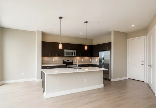 a kitchen with stainless steel appliances a sink and a refrigerator