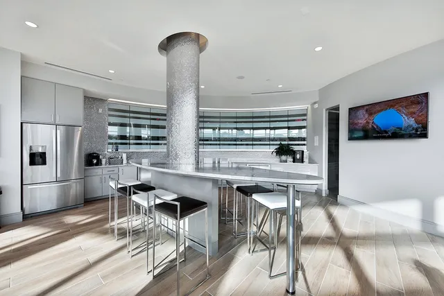 a kitchen with stainless steel appliances a table and chairs in it