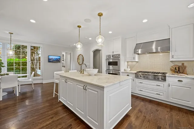 a kitchen with white cabinets stove and sink