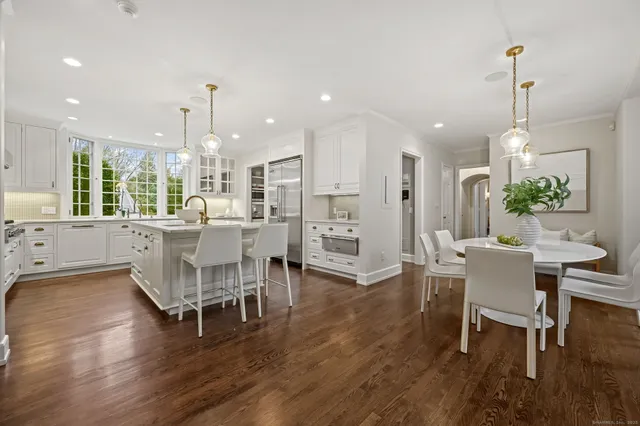 a dining area with furniture a chandelier and wooden floor