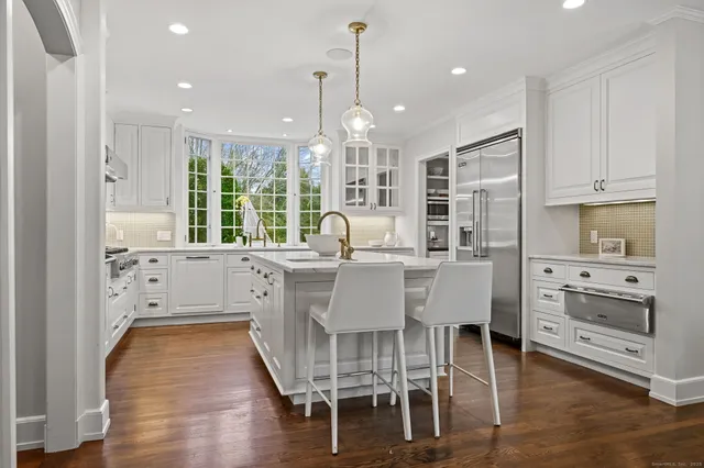a dining room with furniture a chandelier and kitchen view