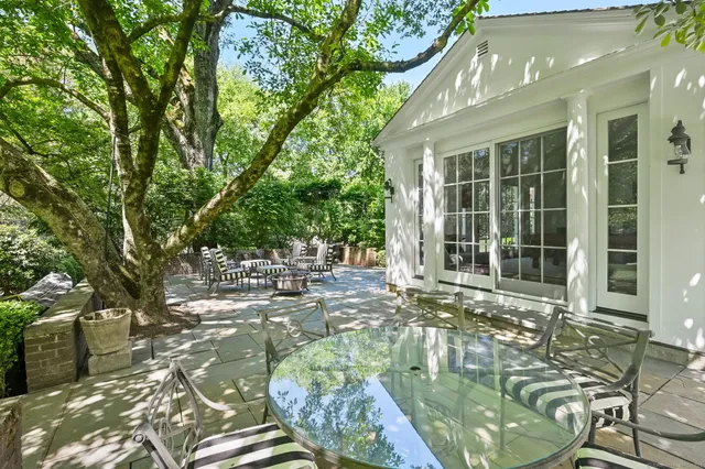 a front view of a house with a garden and trees