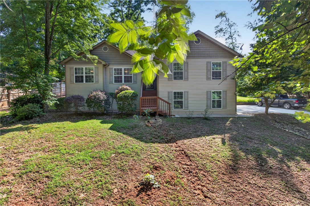 151 Towne Creek Trail Anderson, SC 29621 - Photo 49 of 49 A split-level home with a welcoming front entrance, surrounded by mature trees and lush greenery.