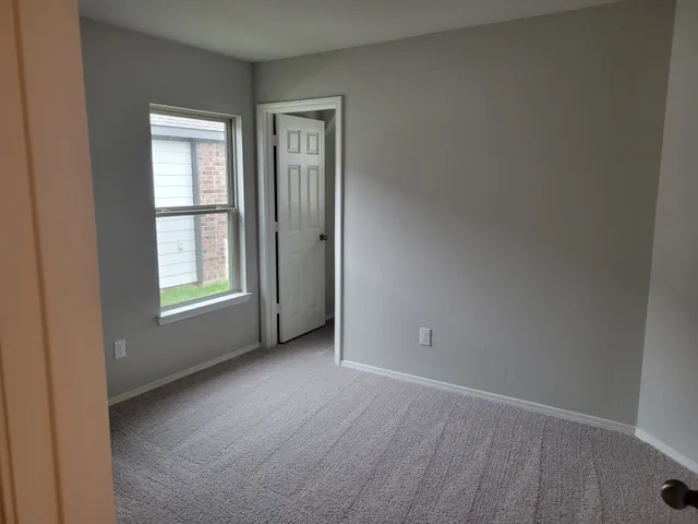 an empty room with windows and closet