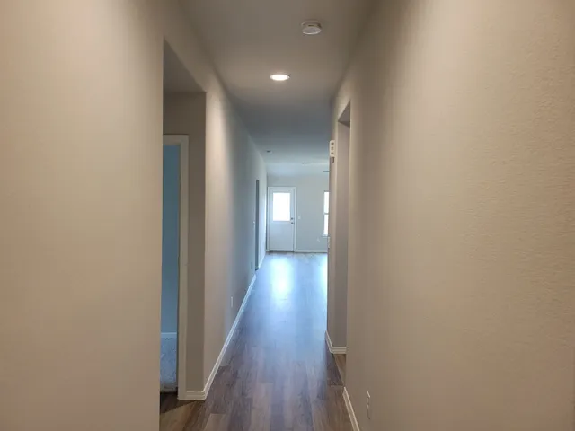 a view of a hallway with wooden floor