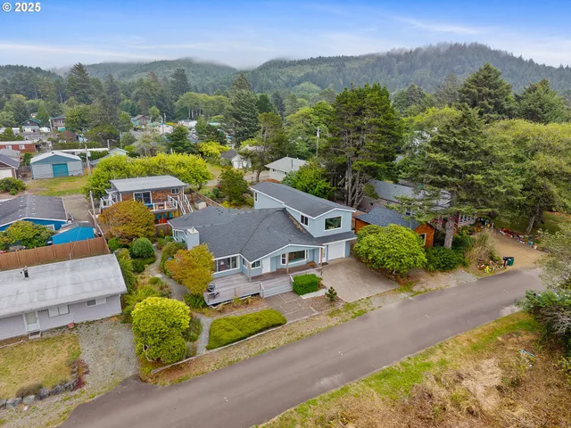 an aerial view of residential houses with outdoor space and trees