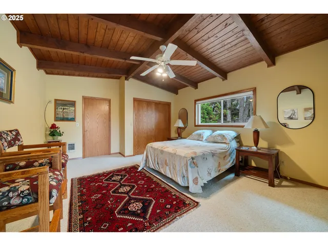 a bedroom with a bed a mirror on dresser and a chandelier