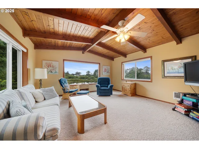 a living room with furniture a flat screen tv and a large window