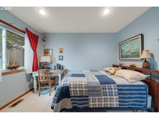 a bedroom with a bed a table and chair