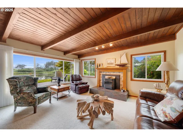 a living room with furniture a fireplace and a large window