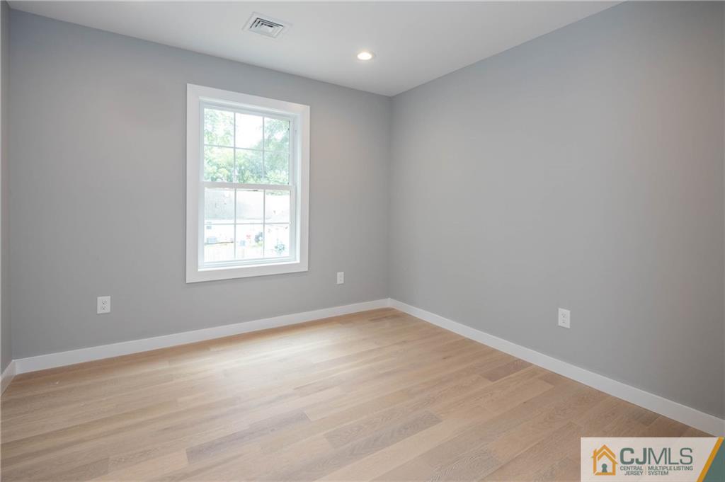 37 Markham Road Edison, NJ 08817 - Photo 27 of 30 an empty room with wooden floor and windows