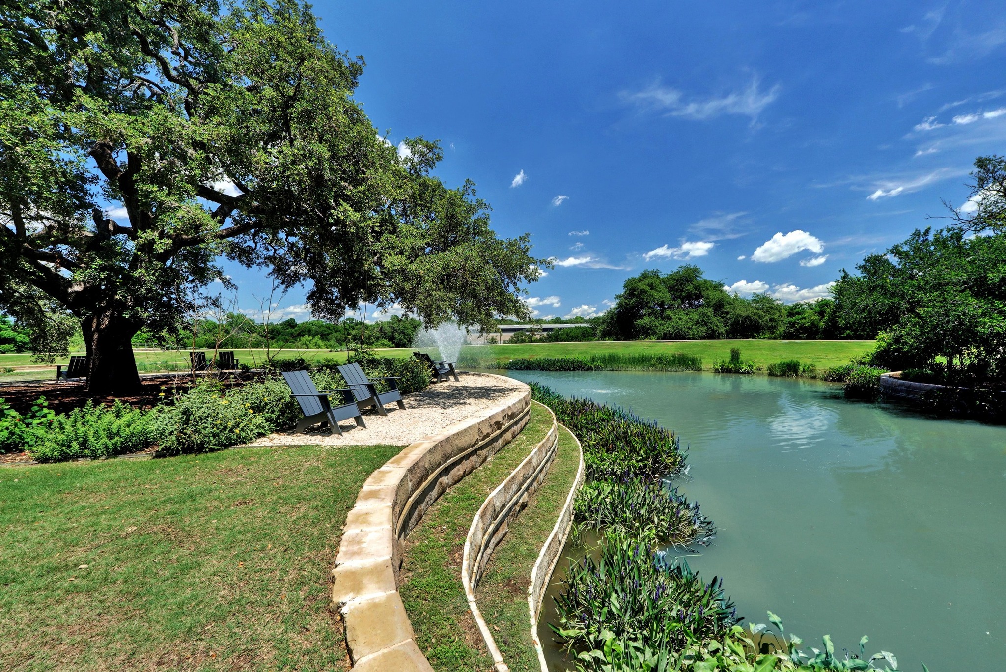 4515 Unity Circle Austin, TX 78731 - Photo 25 of 37 Mature shade trees line the terraced stone banks of a tranquil private pond.