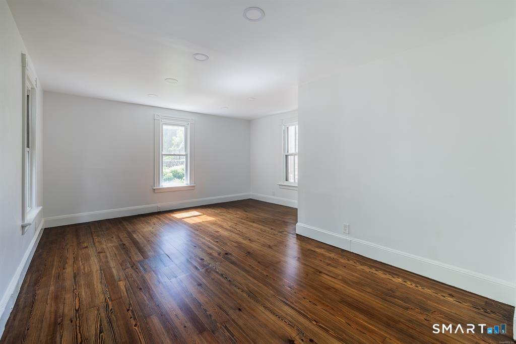 106 Wooster Street Shelton, CT 06484 - Photo 5 of 9 an empty room with wooden floor and windows
