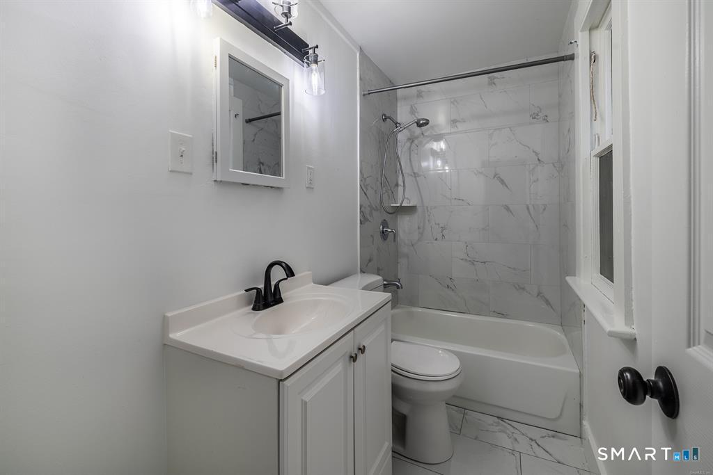 106 Wooster Street Shelton, CT 06484 - Photo 6 of 9 a bathroom with a bathtub shower sink vanity and toilet