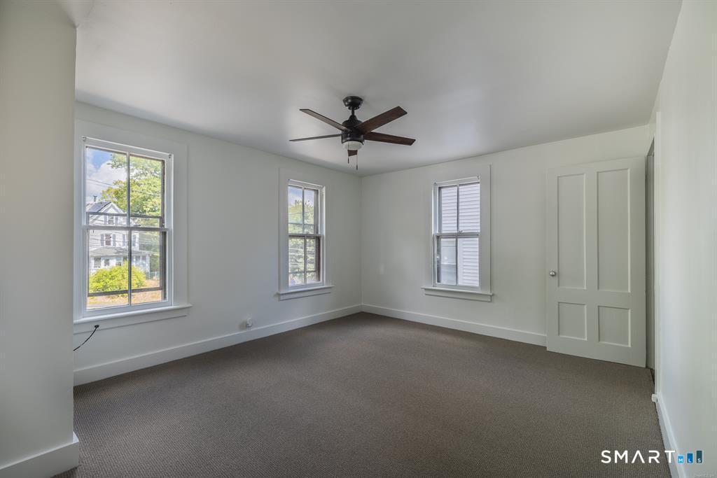 106 Wooster Street Shelton, CT 06484 - Photo 7 of 9 an empty room with windows and chandelier fan