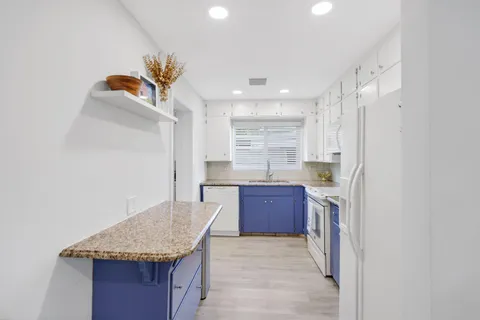 a kitchen with stainless steel appliances granite countertop a sink and a refrigerator