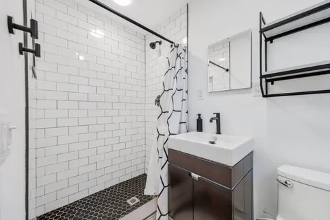 a bathroom with a sink a toilet and shower