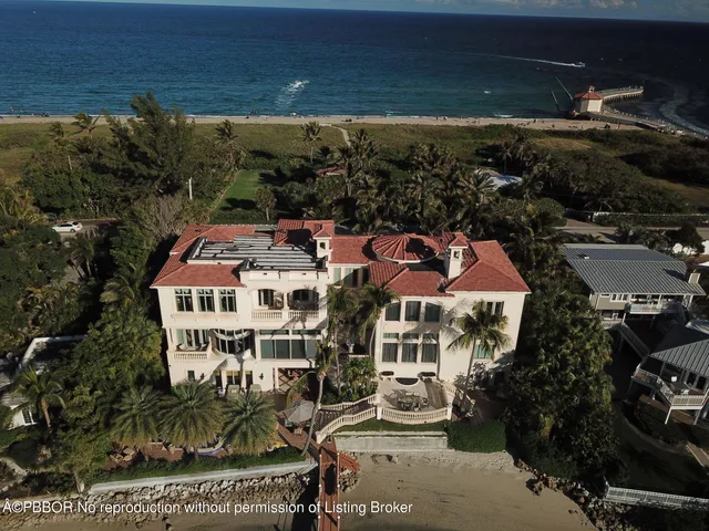 an aerial view of a house with a garden and lake view