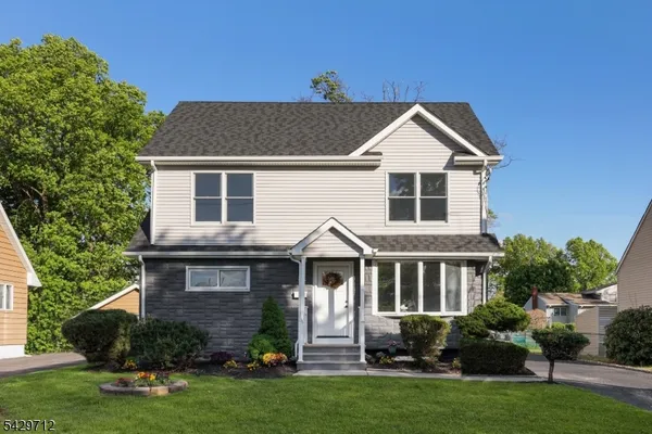 a front view of a house with a yard and green space
