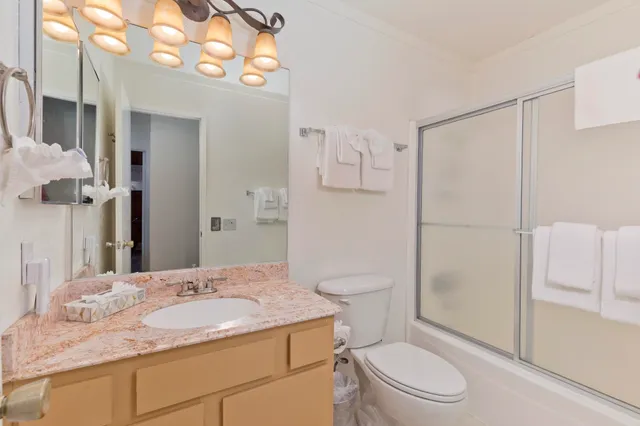a bathroom with a granite countertop sink toilet and shower