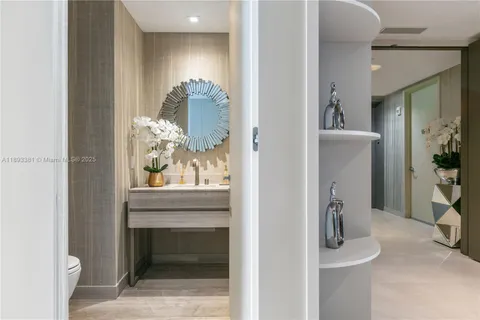 a hallway with painting and potted plants