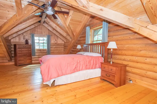 a spacious bedroom with a bed and a wooden floor