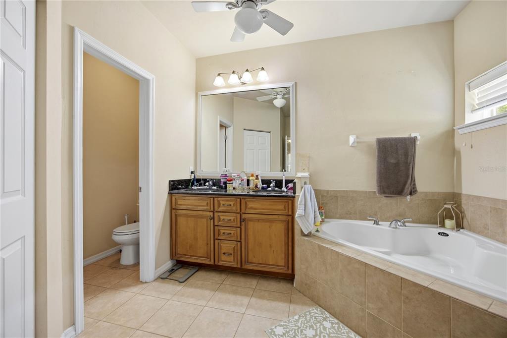 7550 Southwest 81st Way Gainesville, FL 32608 - Photo 18 of 31 a spacious bathroom with a granite countertop tub sink and mirror
