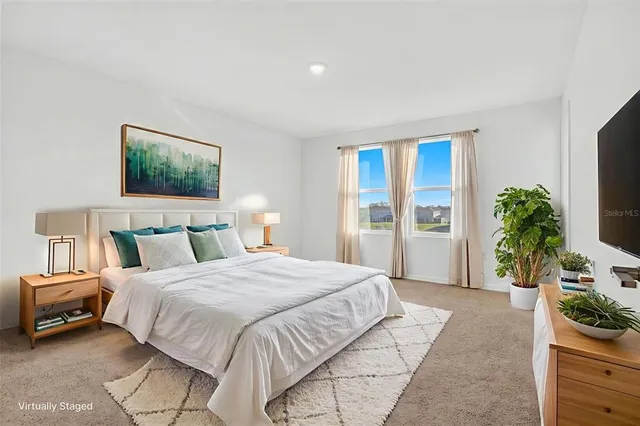 a spacious bedroom with a bed and a potted plant