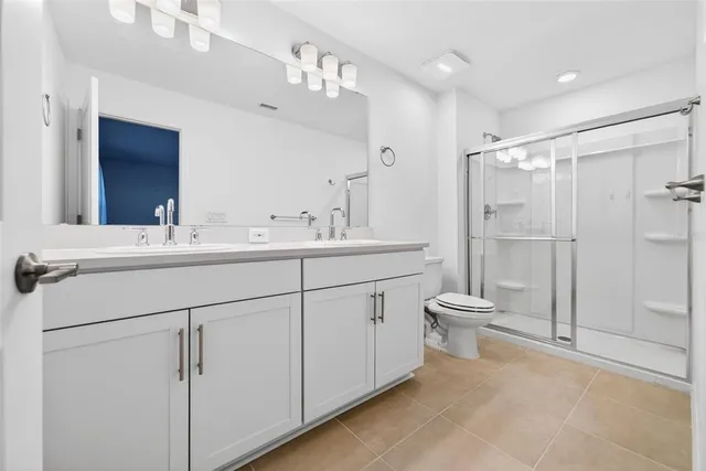 a bathroom with a double vanity sink mirror and toilet