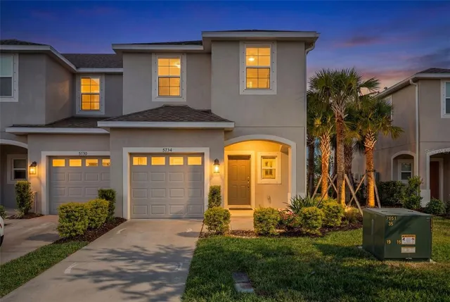 a front view of a house with garden and parking