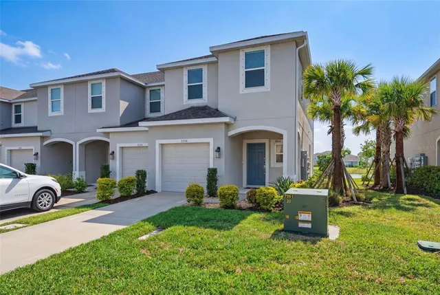 a view of a white house next to a yard