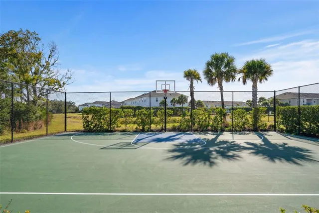 a sign board with flower plants and wooden fence