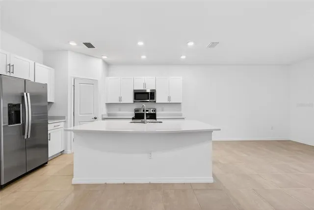 a view of kitchen with stainless steel appliances a refrigerator and a stove