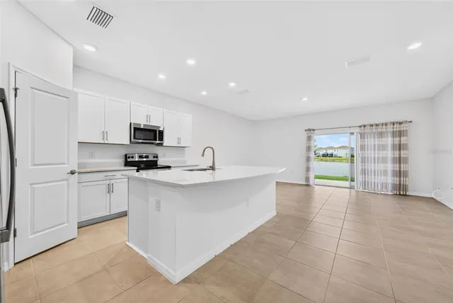 a kitchen with stainless steel appliances a refrigerator sink and microwave